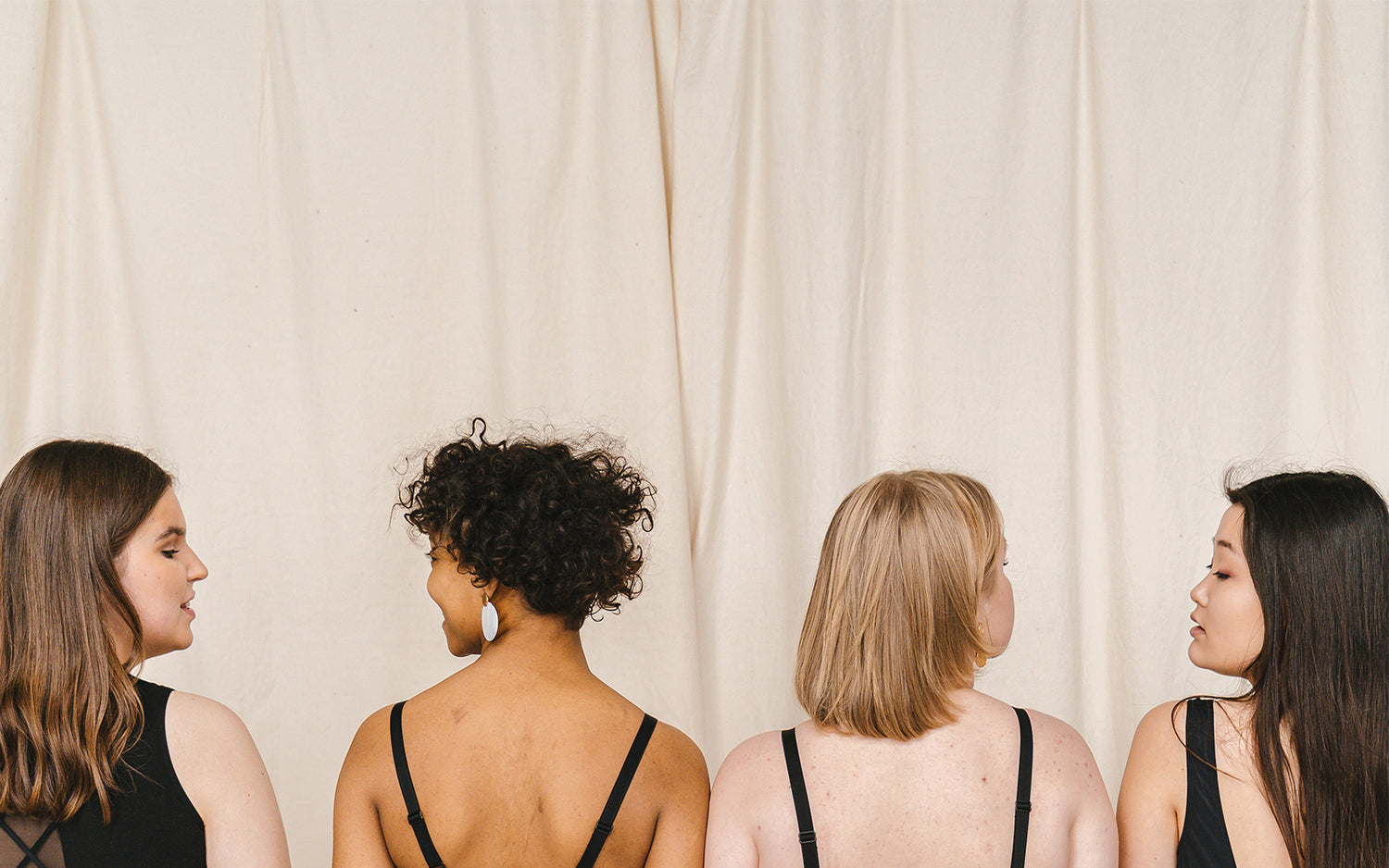 4 people with their backs to the camera smiling at each other
