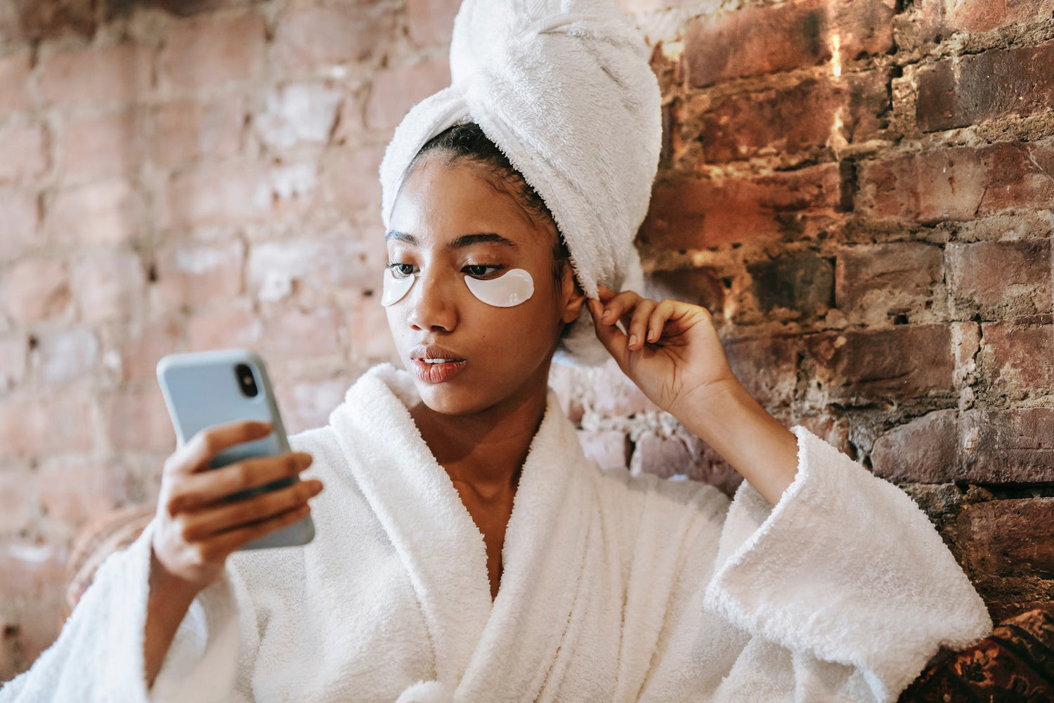 person wearing a robe and eyemask reading their phone