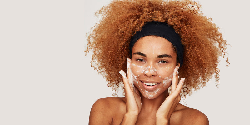 person smiling and washing their face